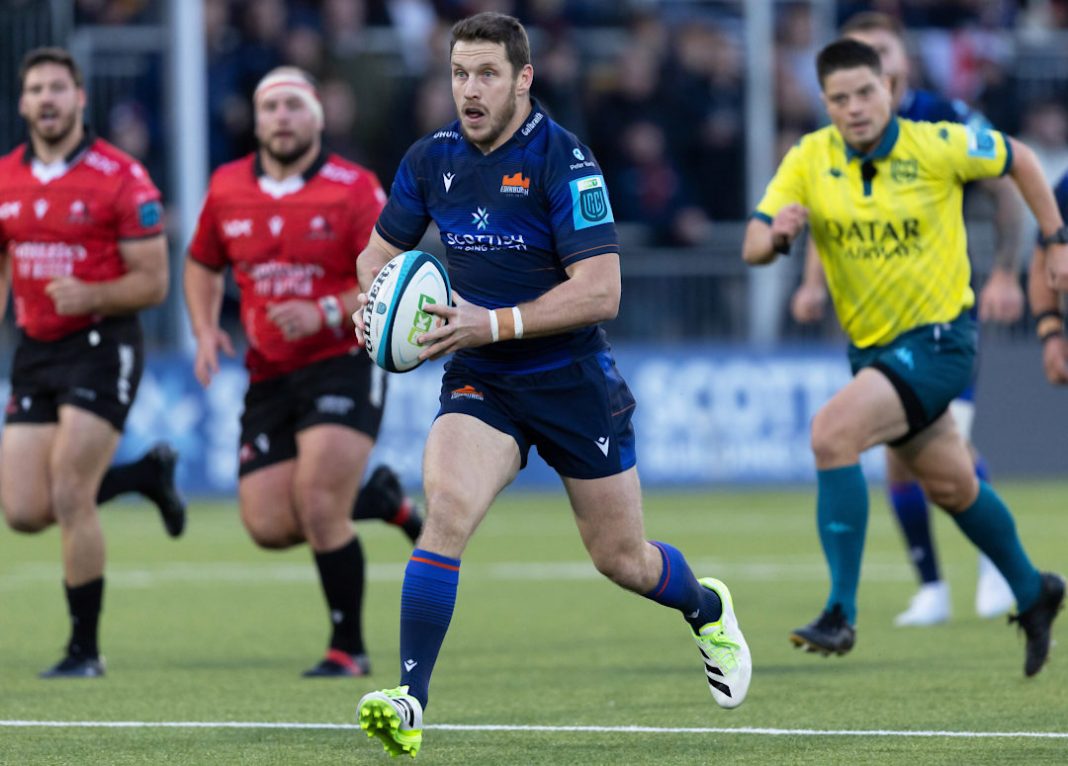 Edinburgh rugby player runs with the ball