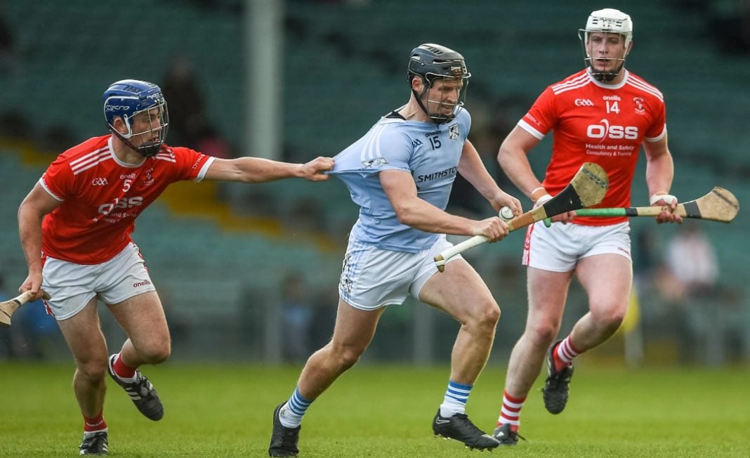 Na Piarsaigh player being held during a hurling match