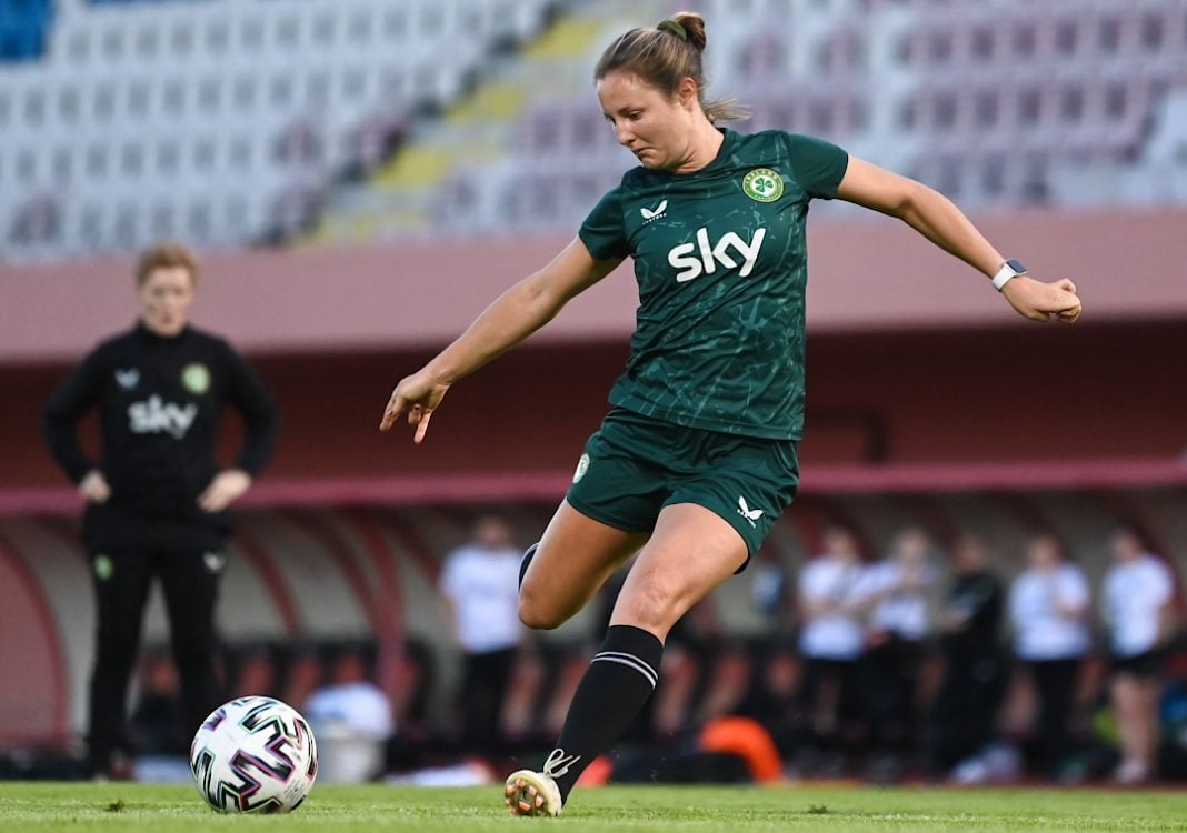 A Republic of Ireland Women's soccer player kicking the ball