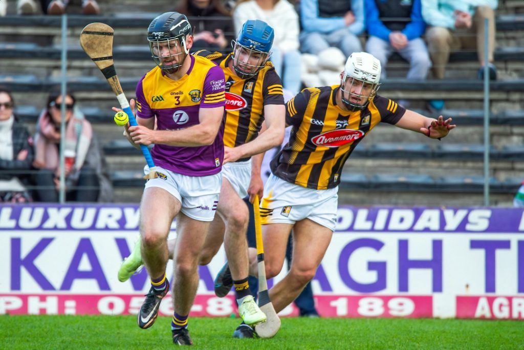 Wexford player running away from Kilkenny defenders 