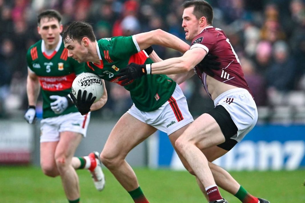 Mayo GAA players shrugging off a Galway player