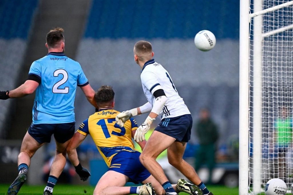 Dublin GAA player kicking the ball past the defenders at the goal