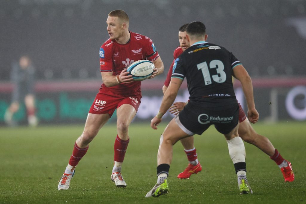 Scarlets player passing the rugby ball