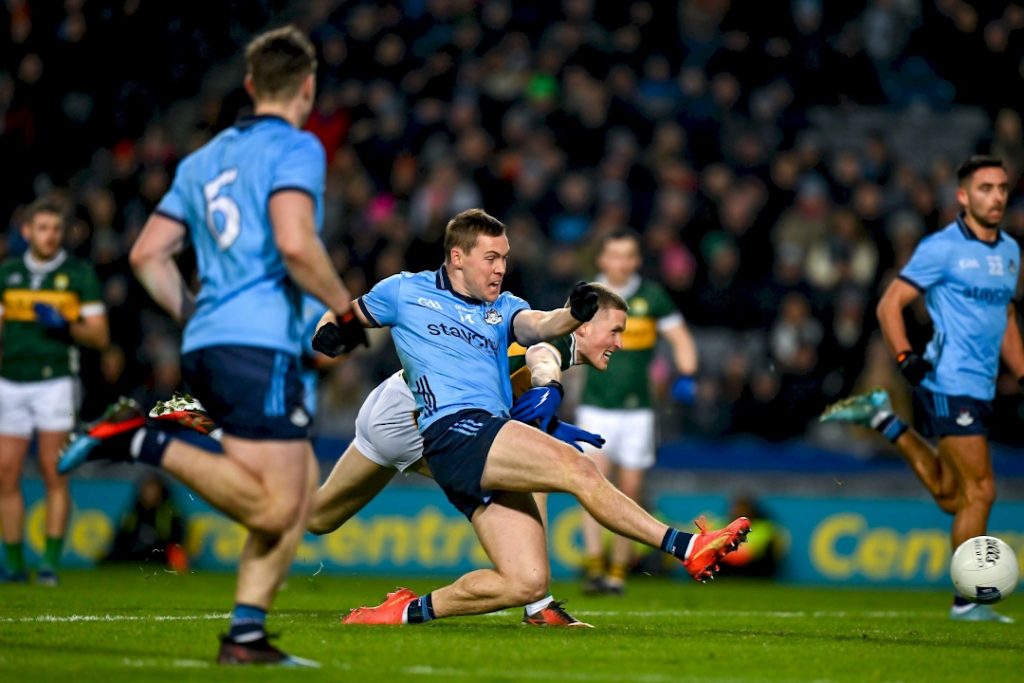 Dublin player sliding to kick the ball
