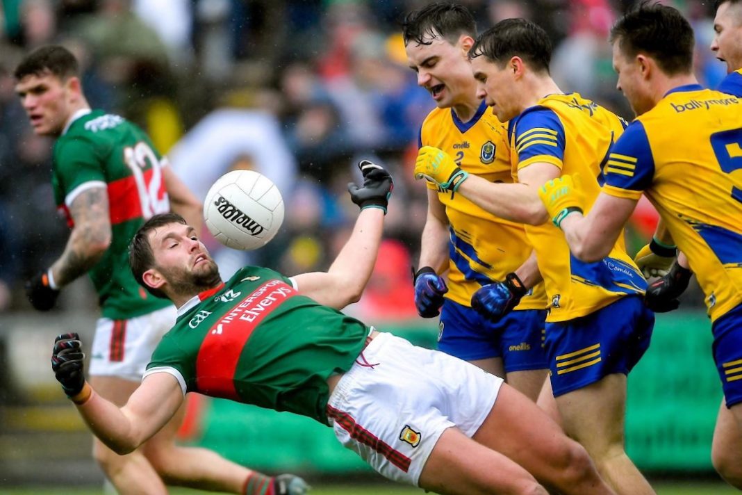 Mayo player falling over with the ball