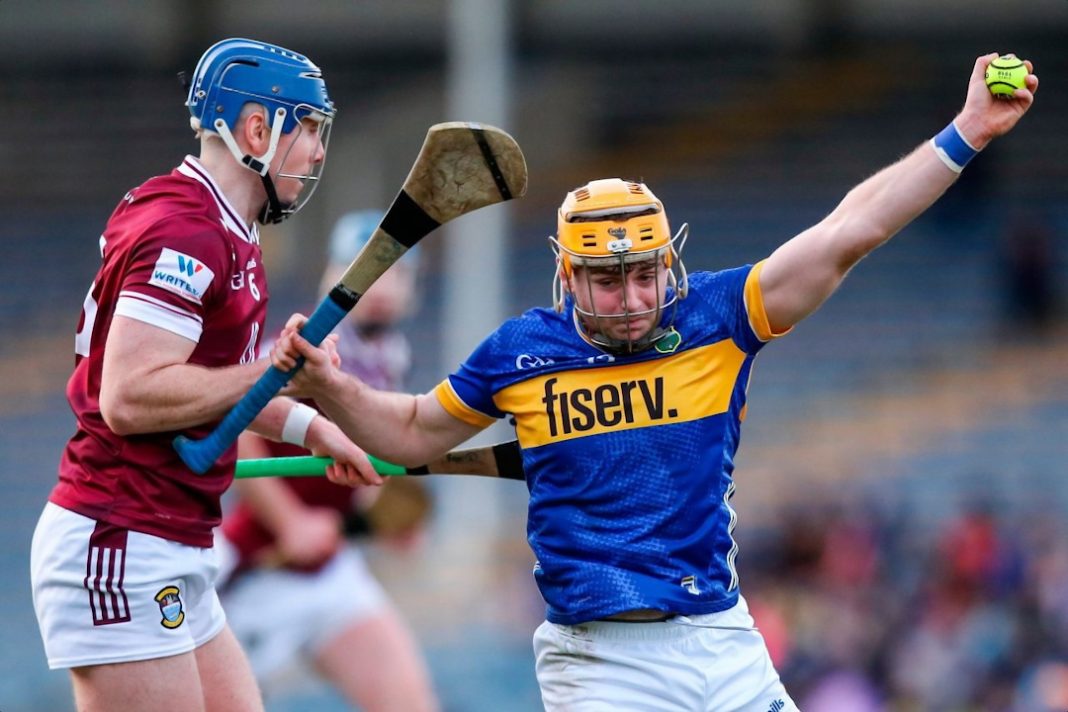 Tipperary hurler wrestling with a defender