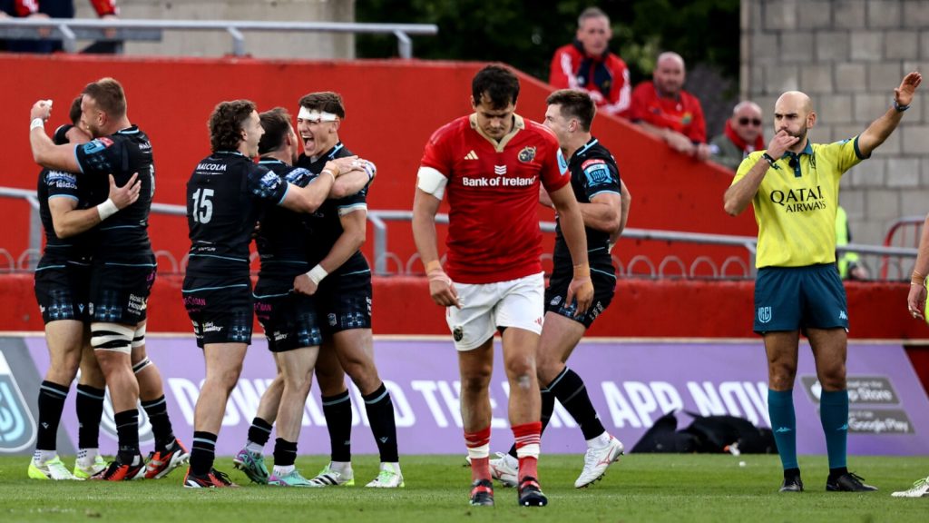 Glasgow players cheer while a Munster rugby player hangs his head in shame