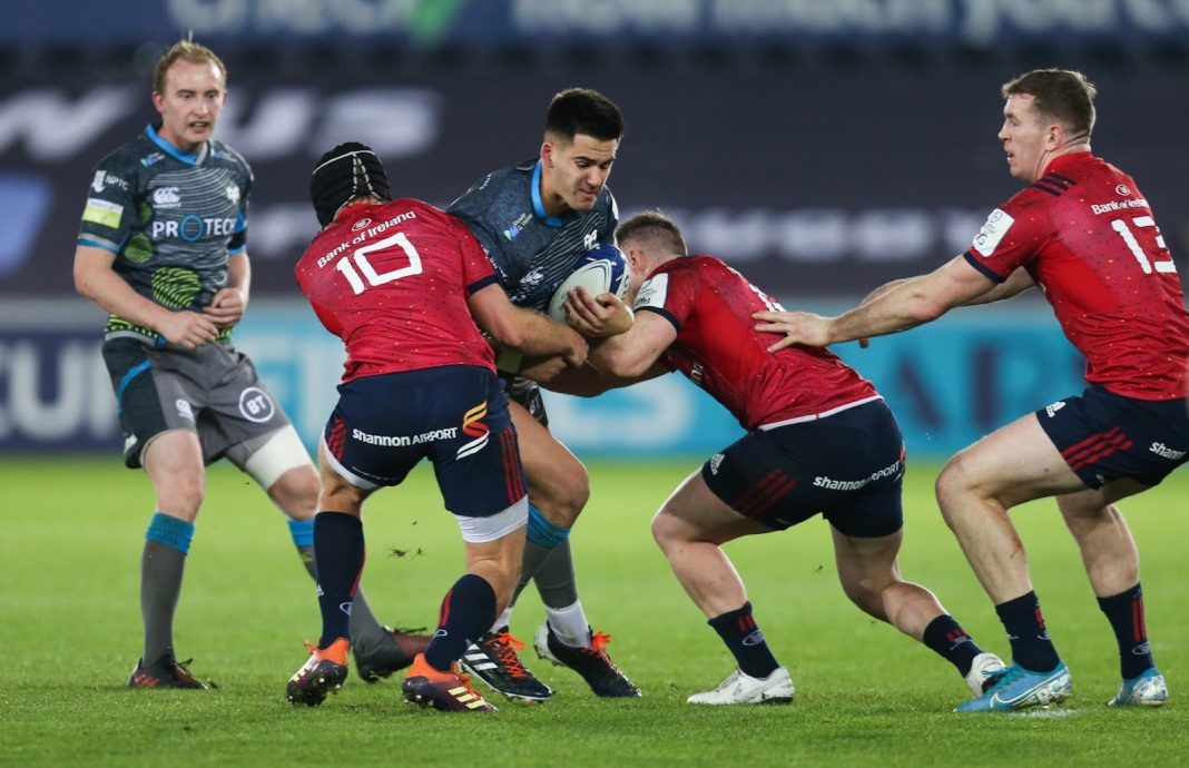 Ospreys player trying to run past Munster defenders