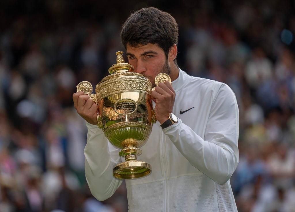 Carlos Alcaraz holding the Wimbledon trophy.