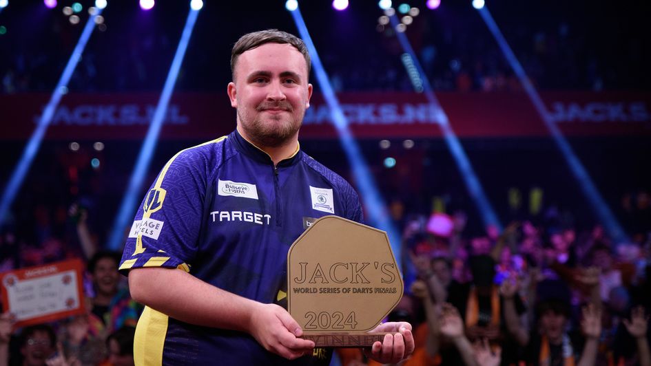 Luke Littler lifting the World Series of Darts trophy in 2024