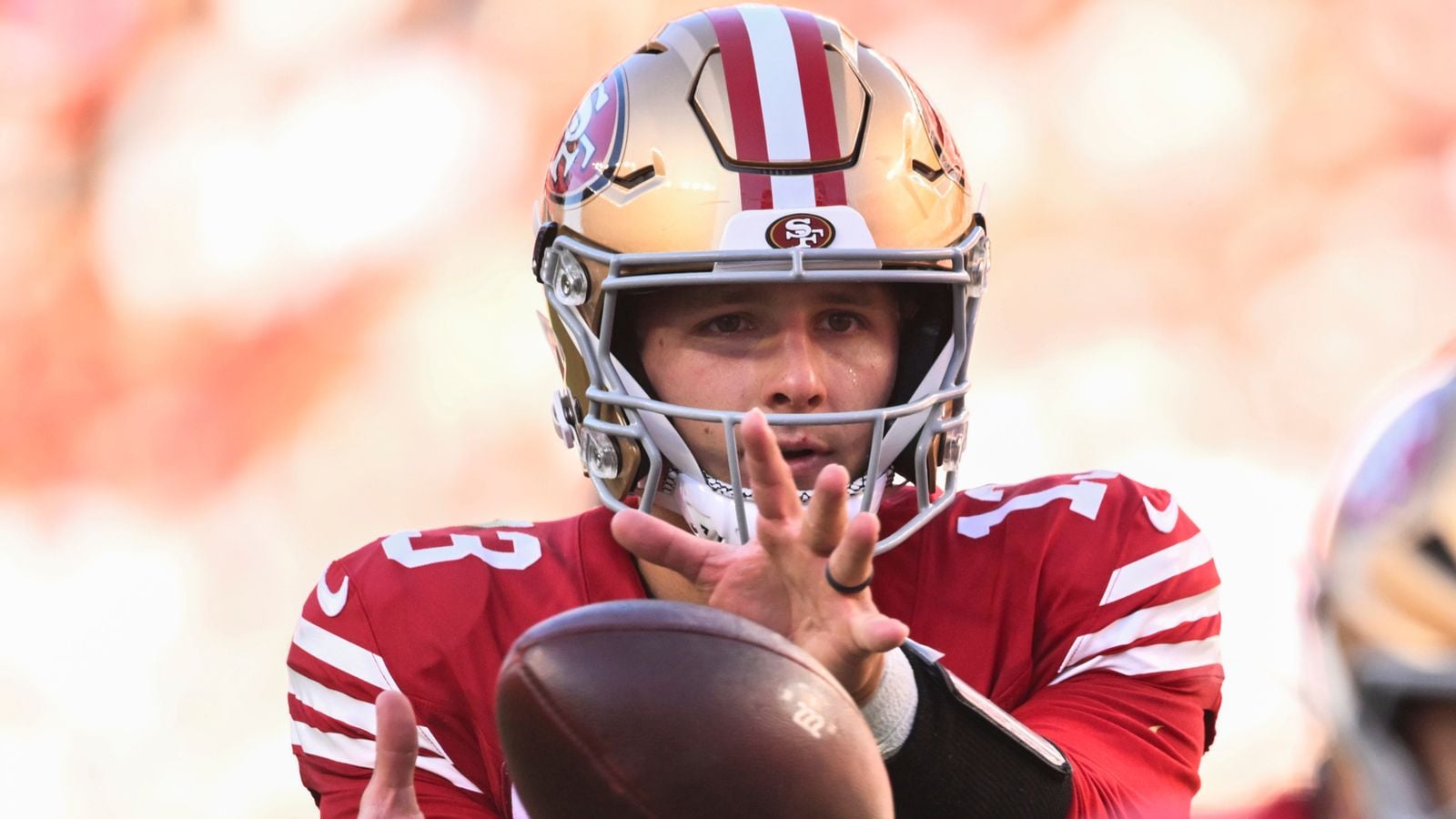 The 9th highest paid NFL player Brock Purdy receiving the ball